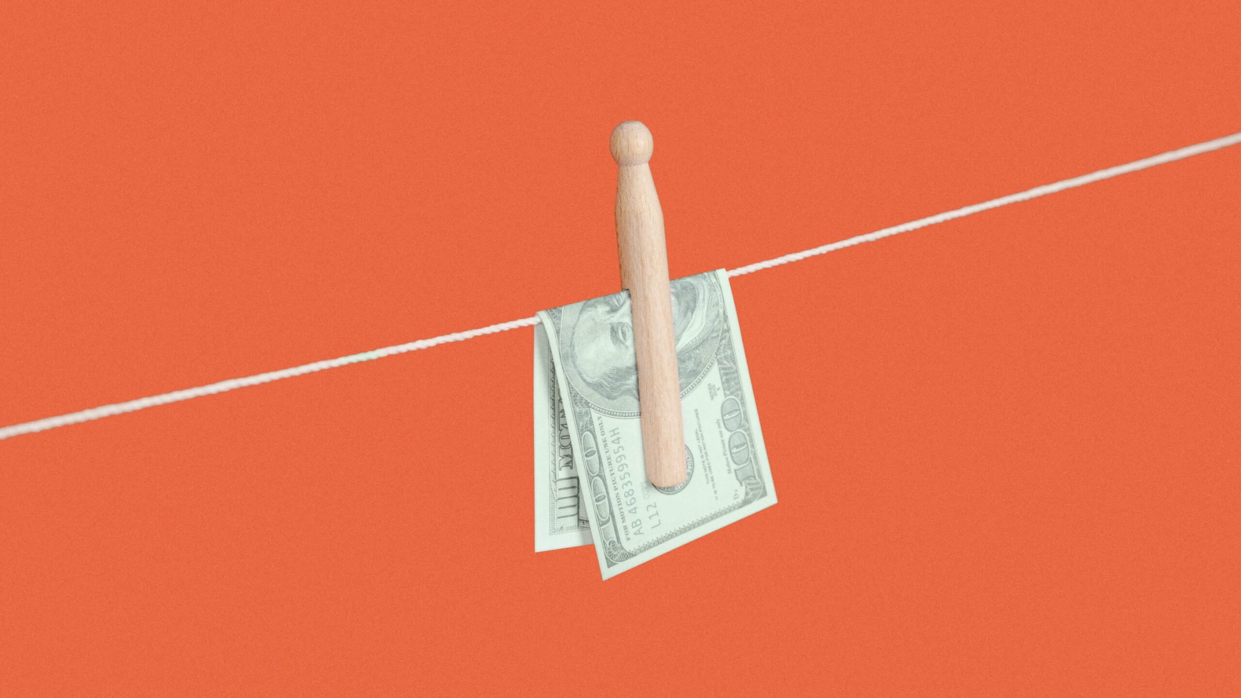 Ein Geldschein wird mit einer Wäscheklammer befestigt.