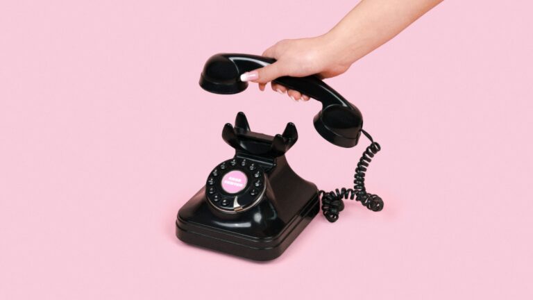 Eine Hand nimmt den Telefonhörer ab