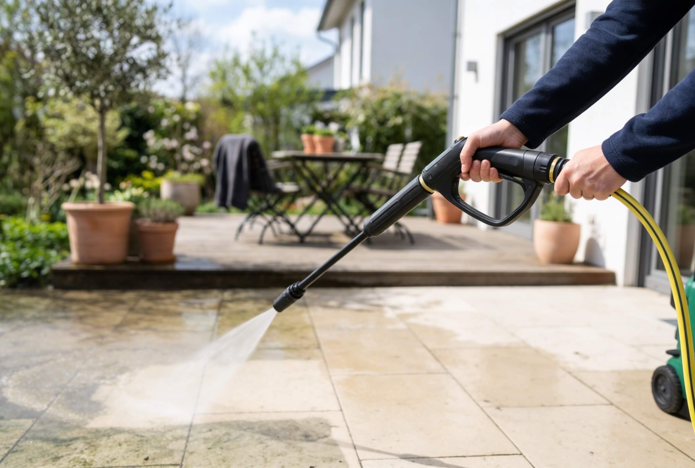 Terrasse reinigen mit Hochdruckgerät, Fliesen werden abgespritzt