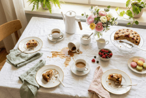Kaffeeflecken auf einem gedeckten Tisch mit Kuchen